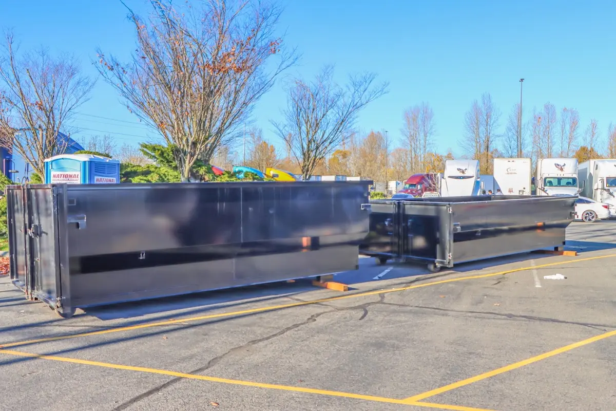 Professional dumpster rental service with roll-off container on residential driveway in Bogota